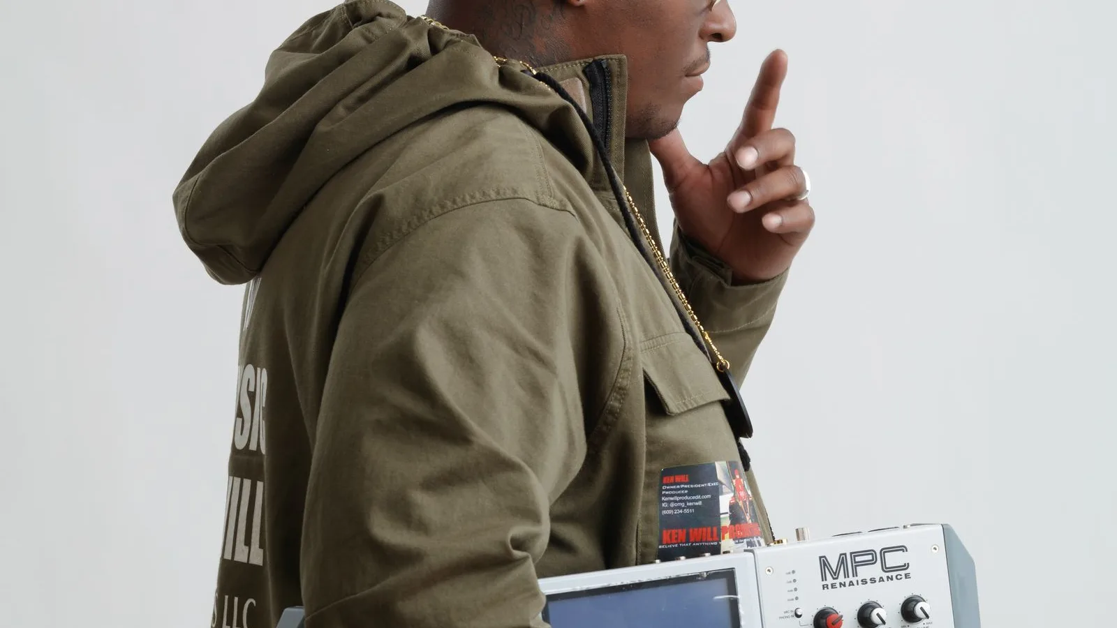 Music producer holding an Akai MPC Renaissance against a white studio backdrop