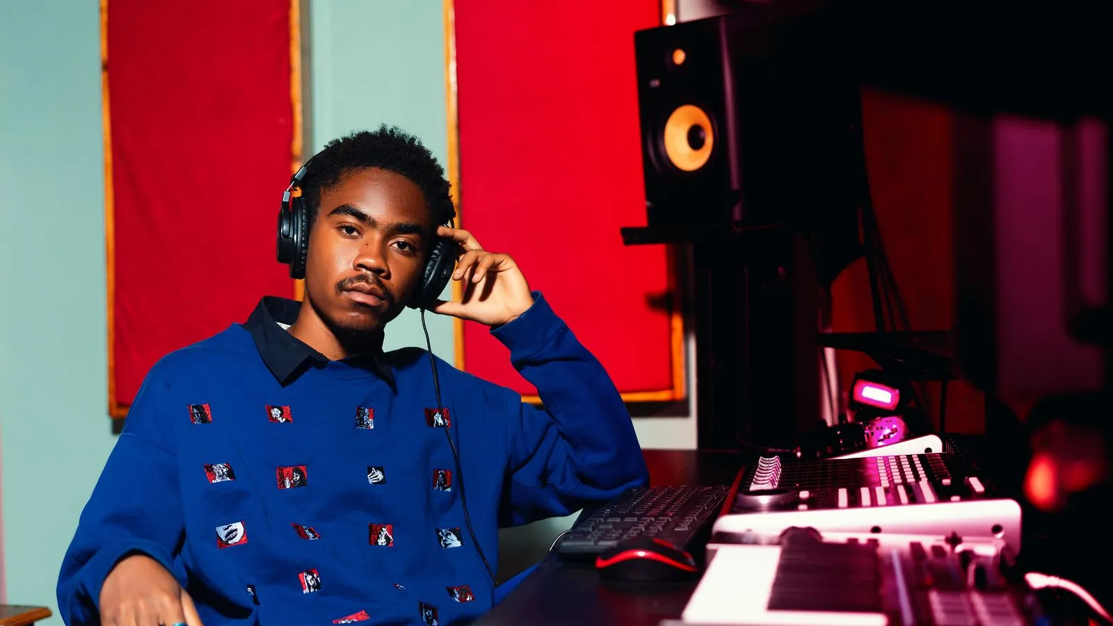 Young music producer with headphones working on electronic tracks in a recording studio