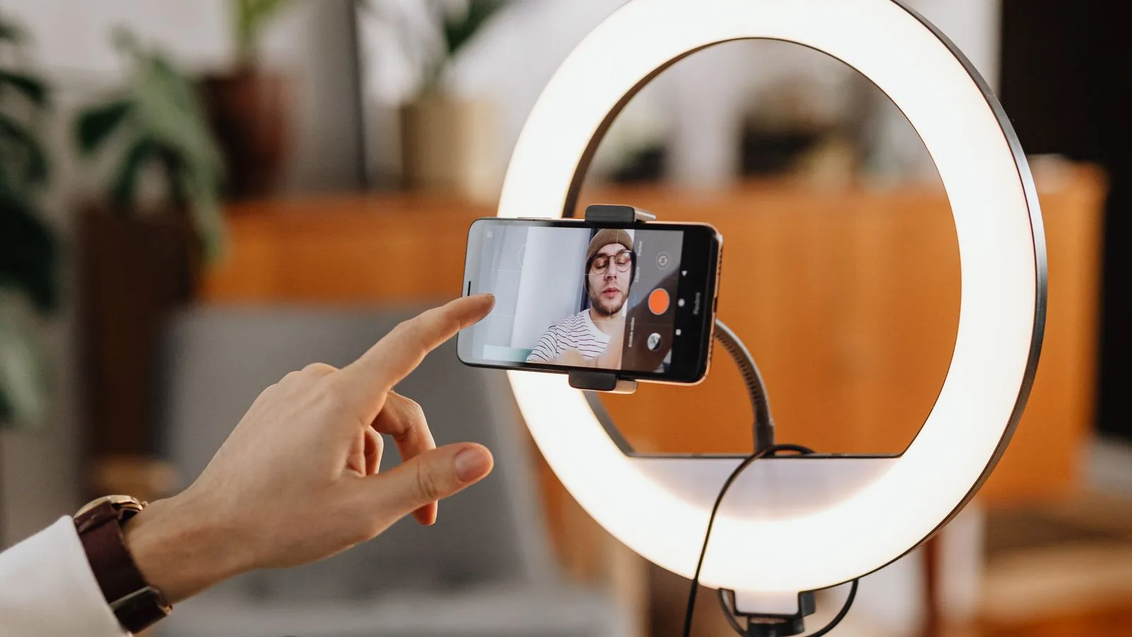 Creator recording short-form video on a phone in a ring light while producing on a tablet DAW